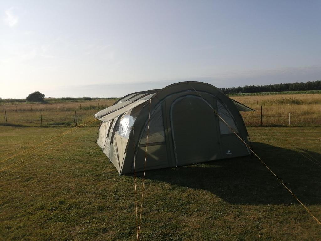 une tente noire et argentée dans un champ dans l'établissement tente en baie de somme chez l habitant, à Cayeux-sur-Mer