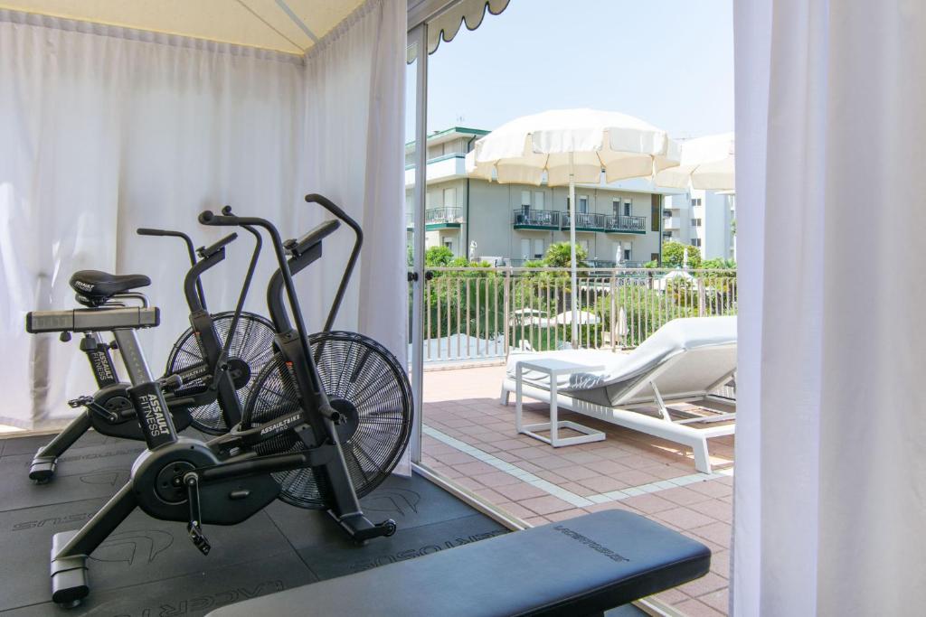 - un vélo sur un tapis roulant dans une chambre avec balcon dans l'établissement Park Hotel Pineta Boutique Hotel, à Caorle
