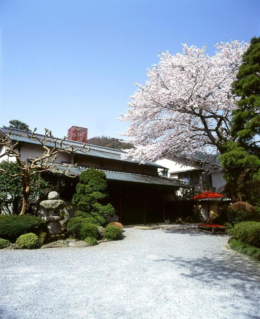 un bâtiment avec un arbre en fleurs devant dans l'établissement Gyokutei, à Hakone