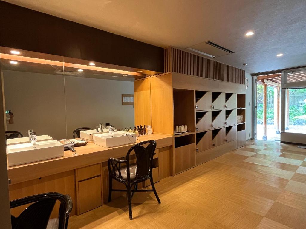 une salle de bain avec deux lavabos et un grand miroir dans l'établissement Spa and Esthetique Suichokan-Female&Adult Only, à Jozankei