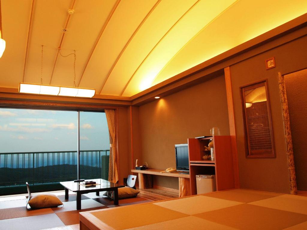 un salon avec une grande fenêtre avec vue dans l'établissement Kounkaku, à Nihommatsu