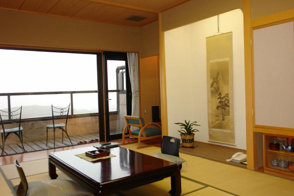 un salon avec une table et une grande fenêtre dans l'établissement Kounkaku, à Nihommatsu