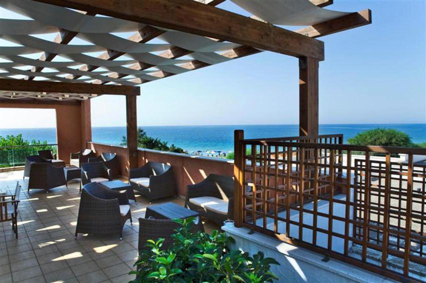 une terrasse avec des chaises et des tables et l'océan dans l'établissement Hotel Club Ravezzo, à Lido Marini