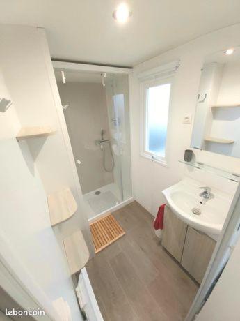 une salle de bain blanche avec un lavabo et une douche dans l'établissement Mobil home climatisé 6pers. 3CH camping domaine de chaussy 5* Ardèche, à Lagorce