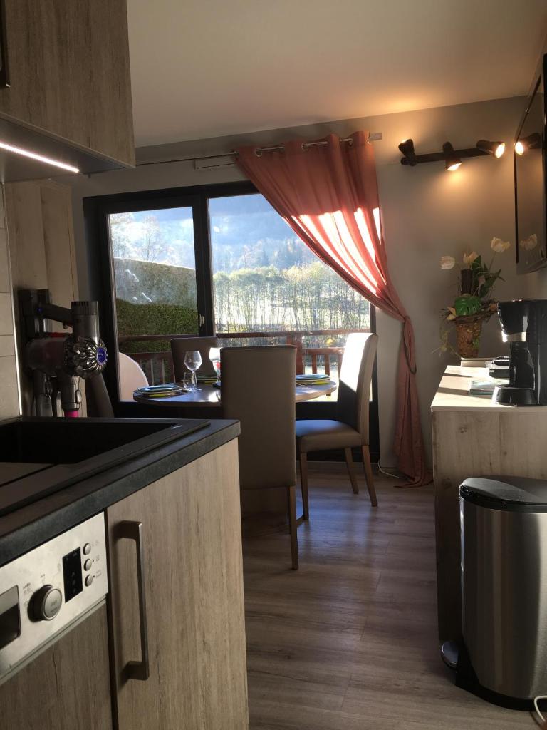 une cuisine et une salle à manger avec une table et une fenêtre dans l'établissement Studio Clos des Meurets, à Praz-sur-Arly