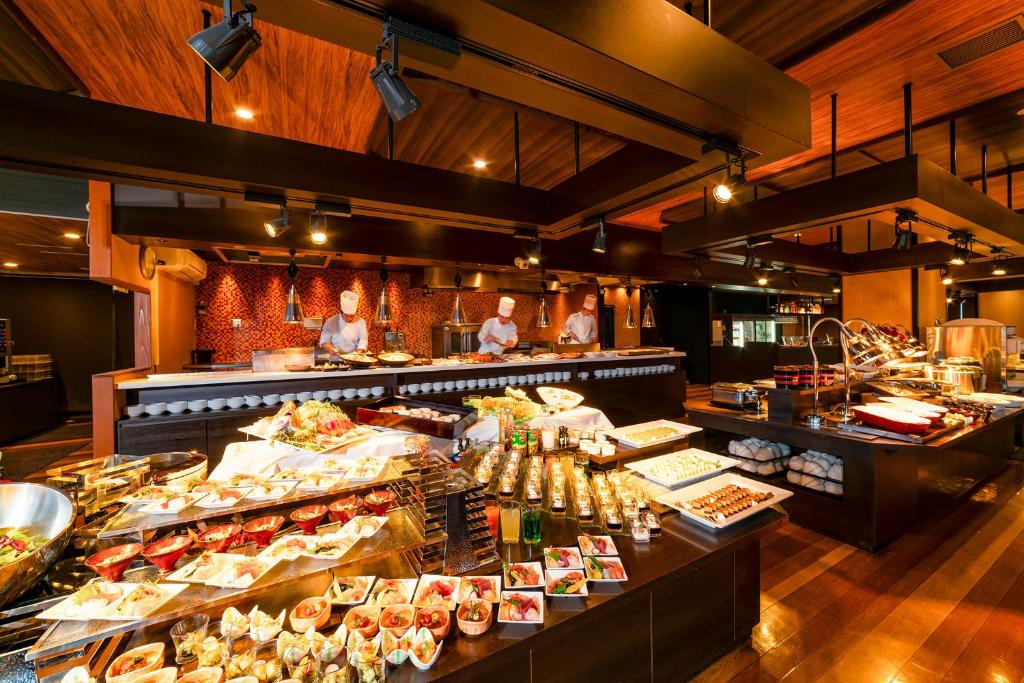 - un buffet avec des personnes debout dans un restaurant dans l'établissement Ooedo Onsen Monogatari Premium Kinosaki, à Toyooka