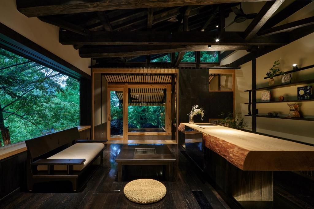 une chambre avec un banc, une table et quelques fenêtres dans l'établissement Hidaji (Adult Only), à Takayama