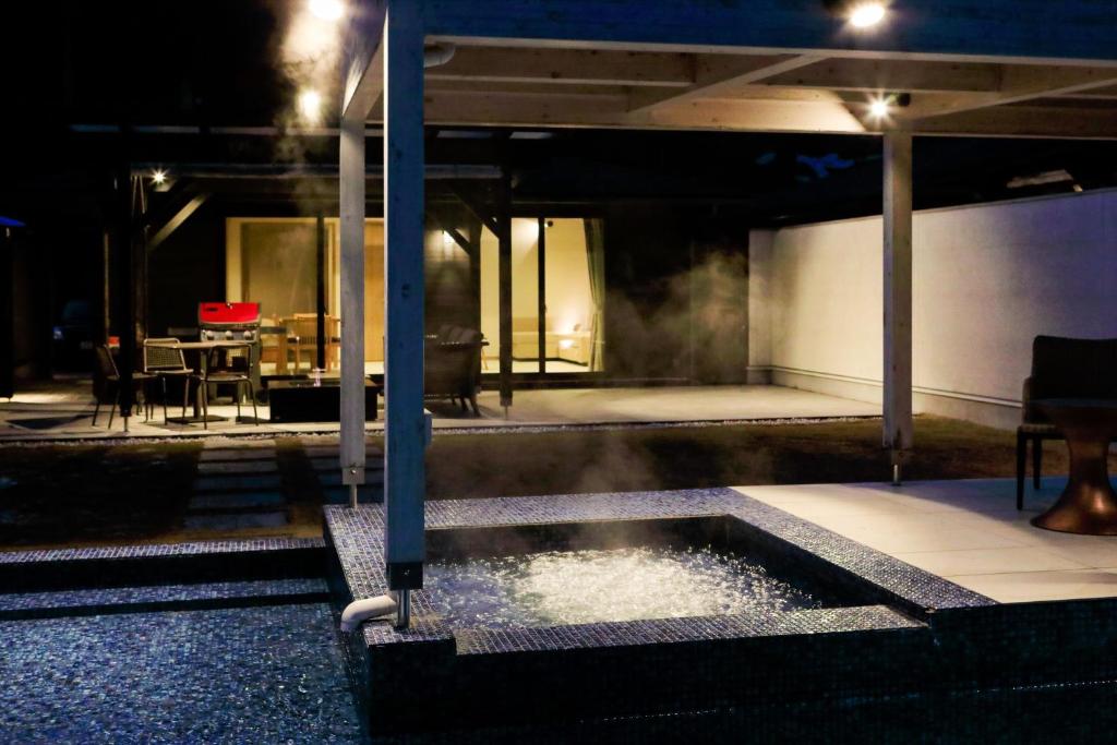 une piscine au milieu d'une maison la nuit dans l'établissement Mezzo ALL SUITE VILLAS, à Miyazu 37 autres photos