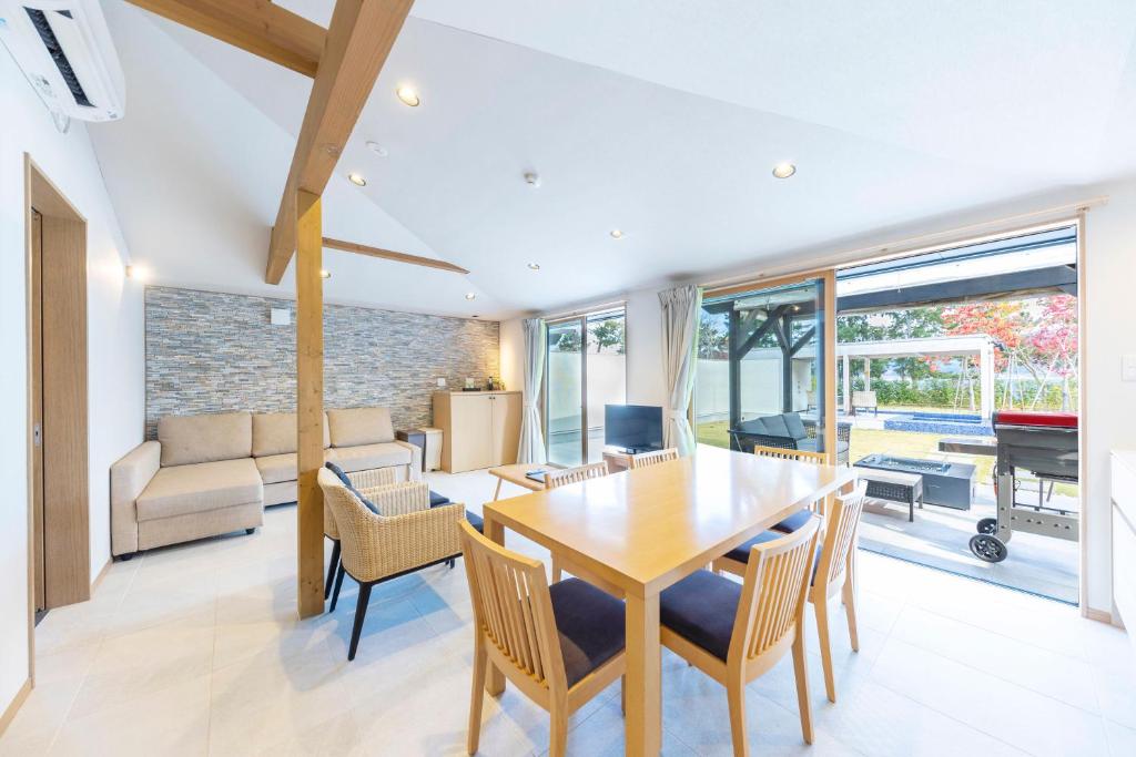 une salle à manger avec une table et des chaises dans l'établissement Mezzo ALL SUITE VILLAS, à Miyazu