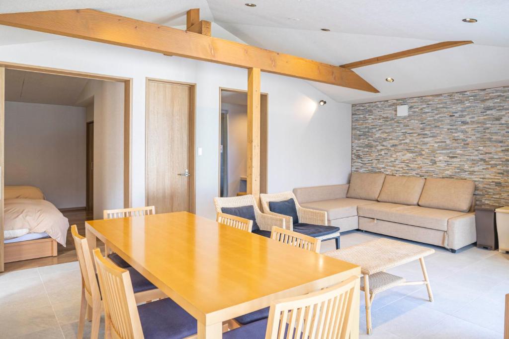 une salle à manger avec une table et des chaises en bois dans l'établissement Mezzo ALL SUITE VILLAS, à Miyazu