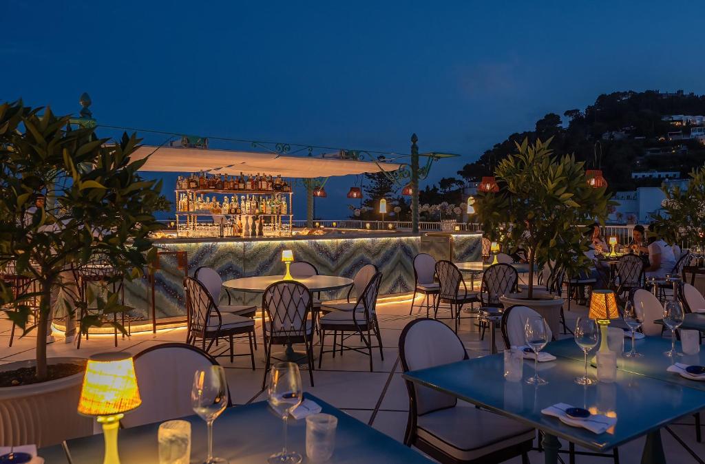 - une terrasse avec des tables et des chaises la nuit dans l'établissement Hotel La Palma, Oetker Hotels, à Capri