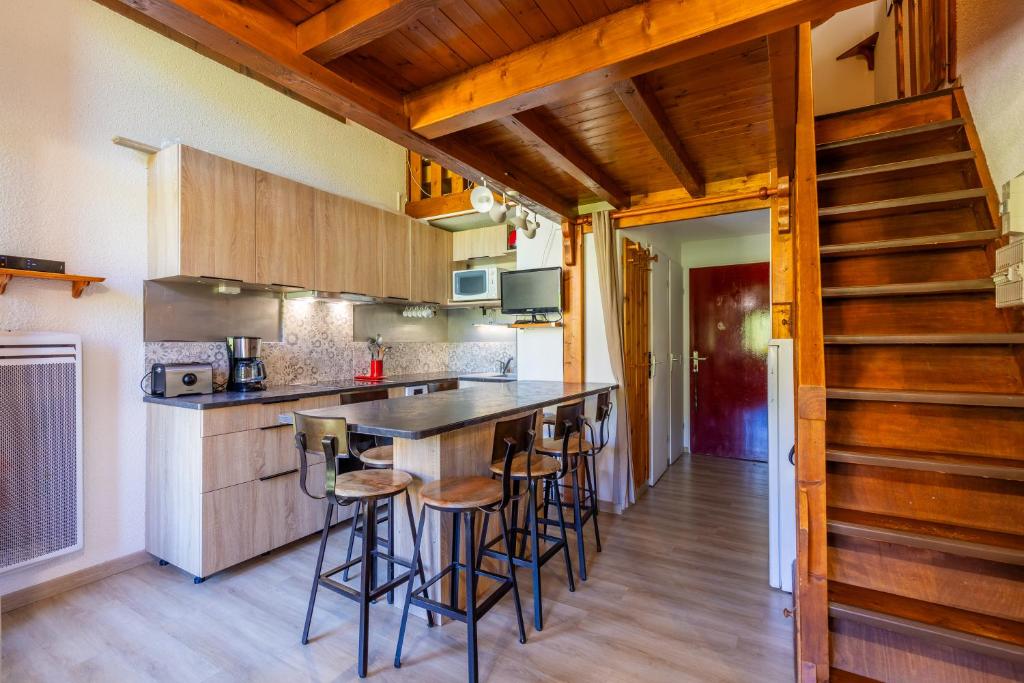 - une cuisine avec un bar et quelques tabourets dans l'établissement Aravis, à Manigod 14 autres photos