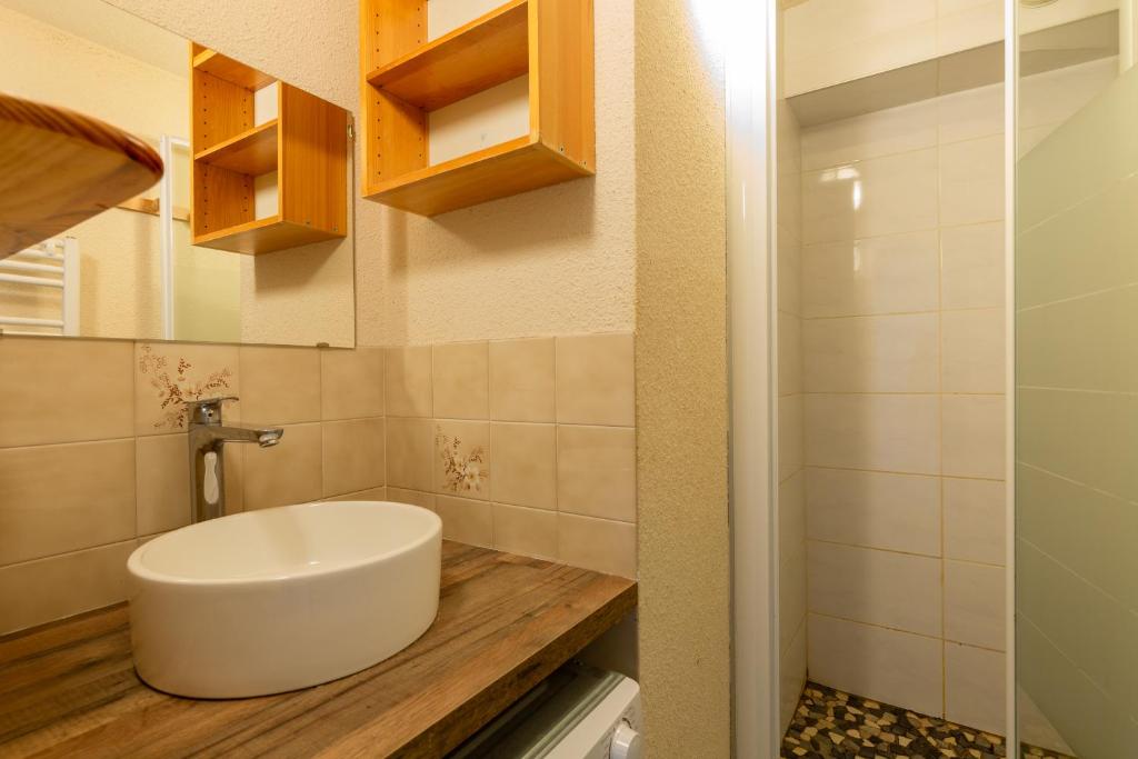 une salle de bain avec un lavabo blanc sur un comptoir en bois dans l'établissement Aravis, à Manigod