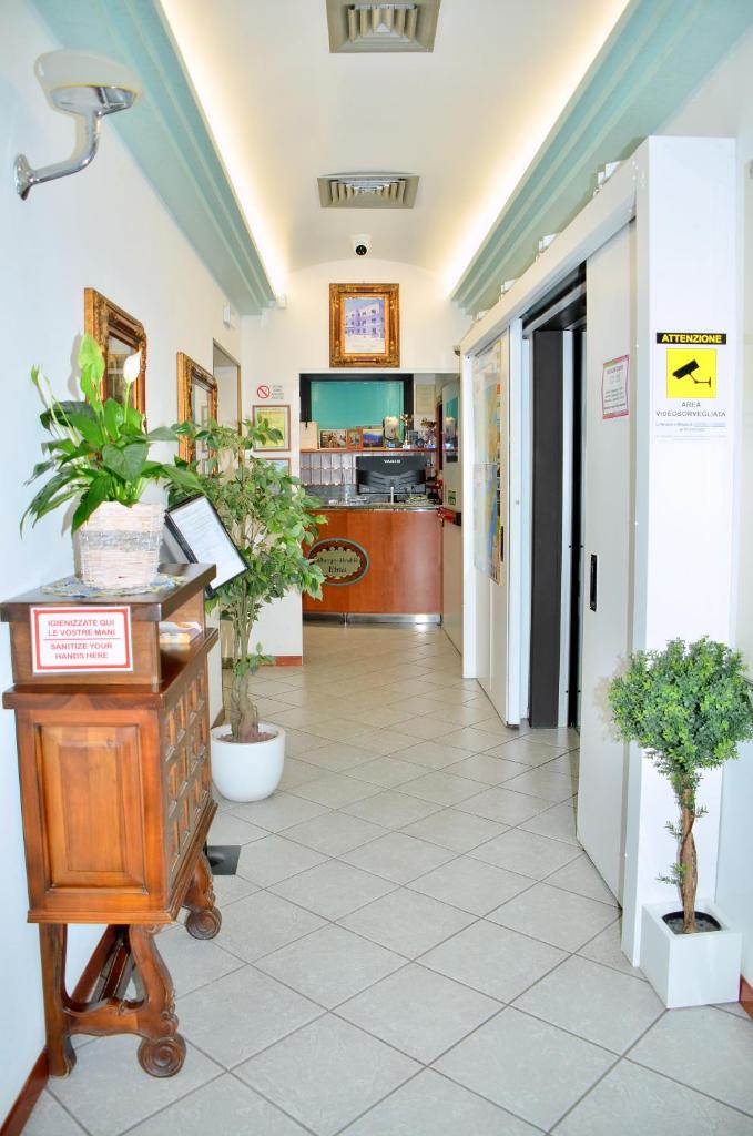 un couloir d'un magasin avec des plantes en pot dans l'établissement Hotel Etna, à Lignano Sabbiadoro