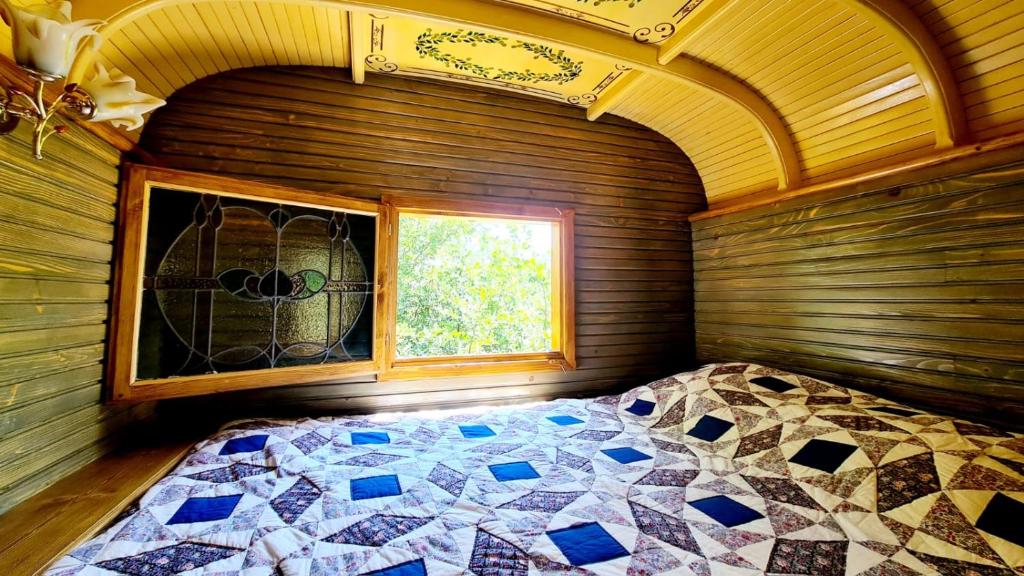 une chambre avec un lit dans une pièce avec une fenêtre dans l'établissement La Roulotte du Coustal, Cajarc, Lot, à Cajarc