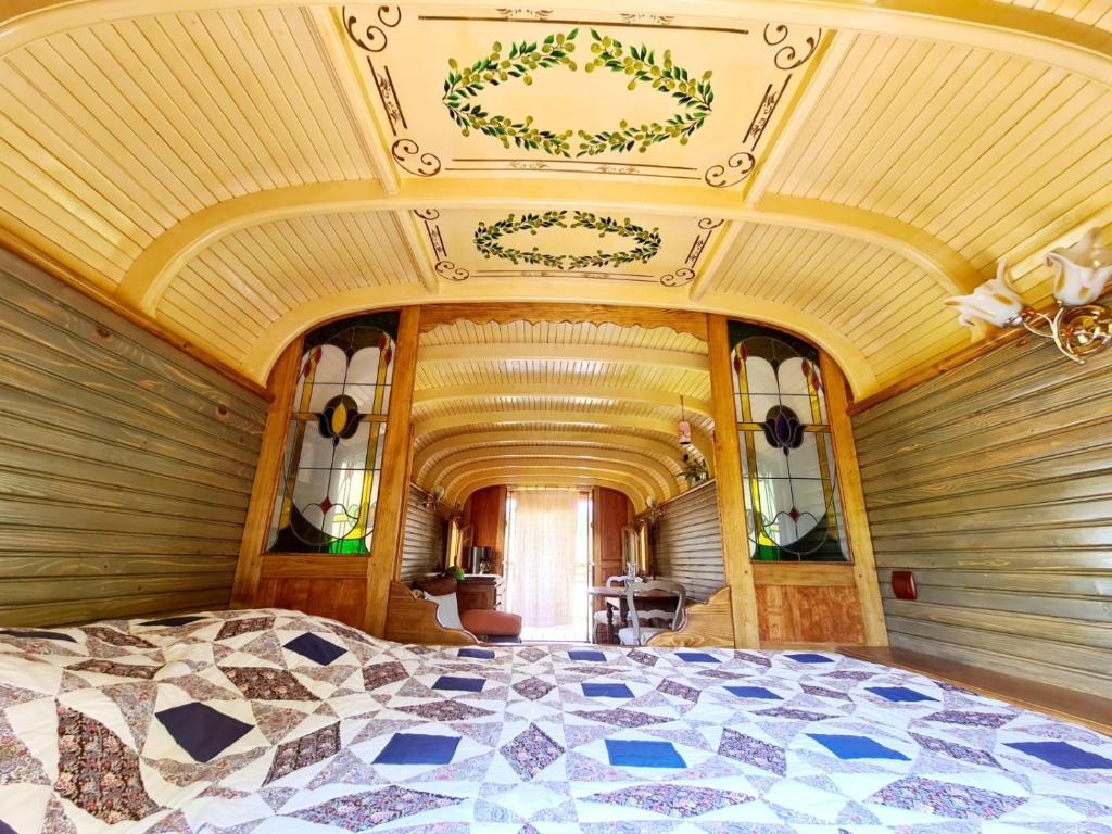 une chambre avec un grand lit avec un plafond dans l'établissement La Roulotte du Coustal, Cajarc, Lot, à Cajarc