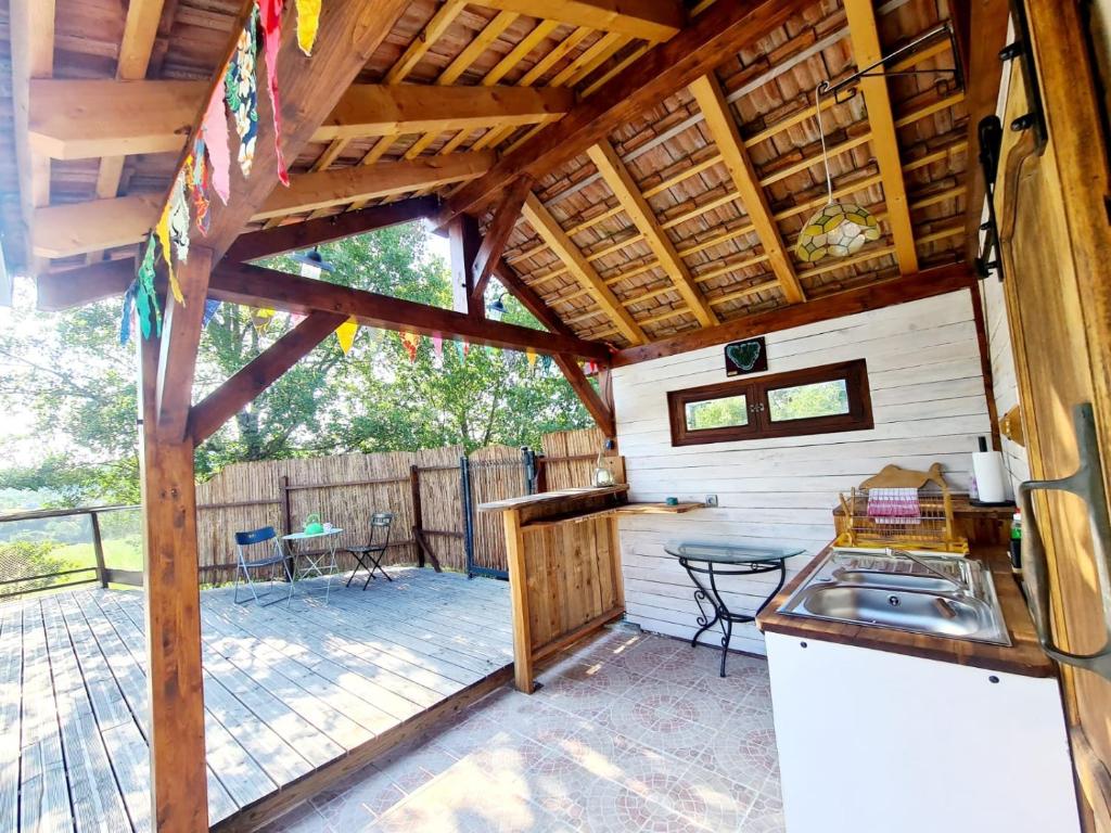 Ce chalet dispose d'une cuisine et d'une terrasse avec une table. dans l'établissement La Roulotte du Coustal, Cajarc, Lot, à Cajarc