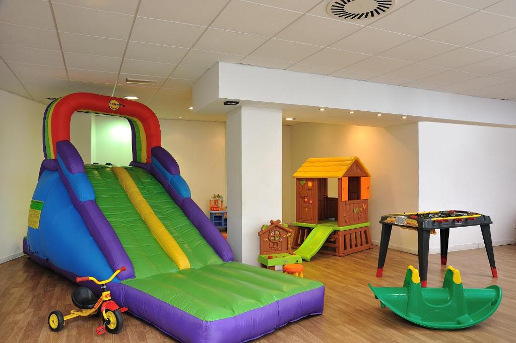 une salle de jeux pour enfants avec un toboggan et une aire de jeux dans l'établissement Hotel Tiberius, à Rimini