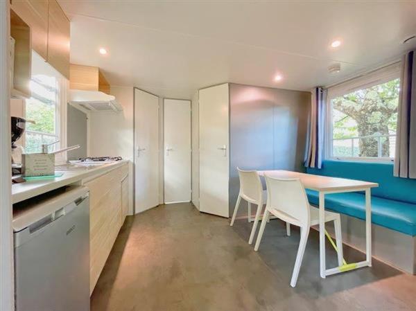une cuisine avec une table et des chaises dans une pièce dans l'établissement Camping L' Arlesienne, à Arles