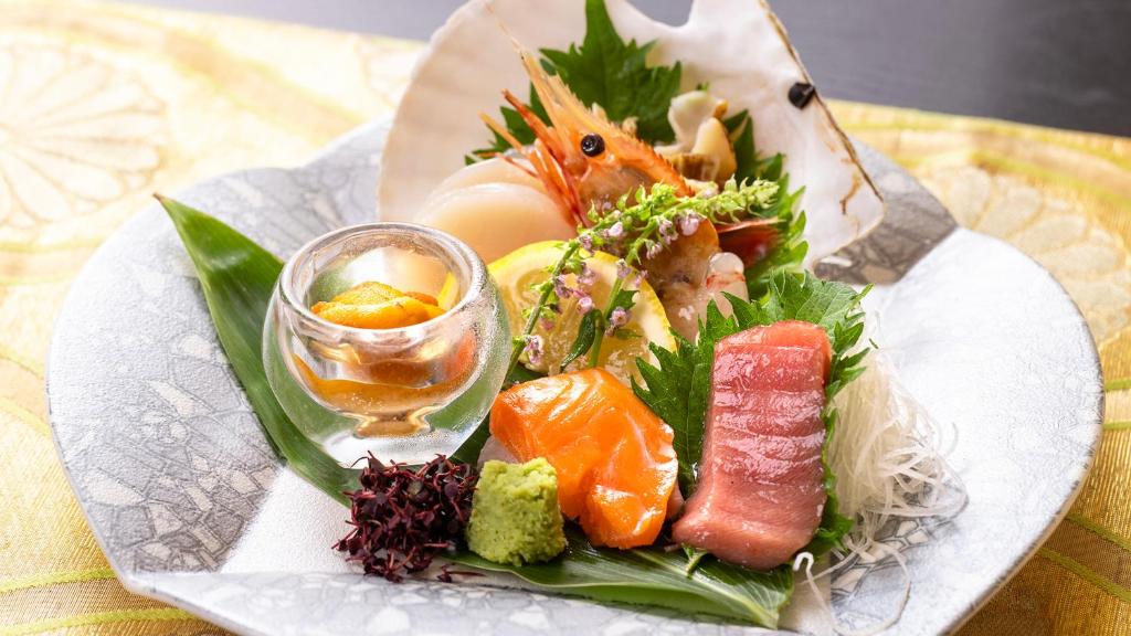 - une assiette de nourriture avec des sushis et une boisson sur une table dans l'établissement Kagariya, à Abashiri