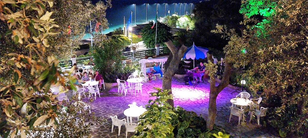 - une vue sur la terrasse dotée de tables et de chaises la nuit dans l'établissement Hotel Villa Ombrosa, à Portoferraio 102 autres photos