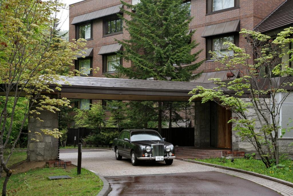 une voiture garée devant un immeuble dans l'établissement Suizantei Club Jozankei-Adults Only, à Jozankei