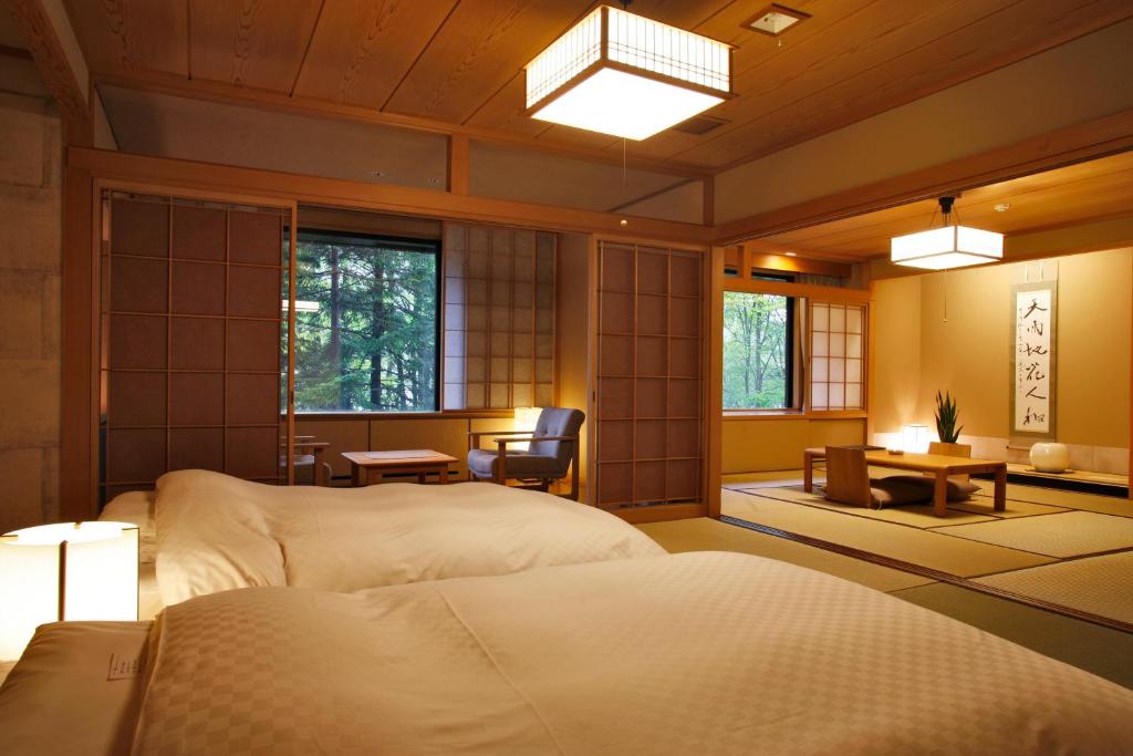 - une chambre japonaise avec 2 lits et un bureau dans l'établissement Suizantei Club Jozankei-Adults Only, à Jozankei