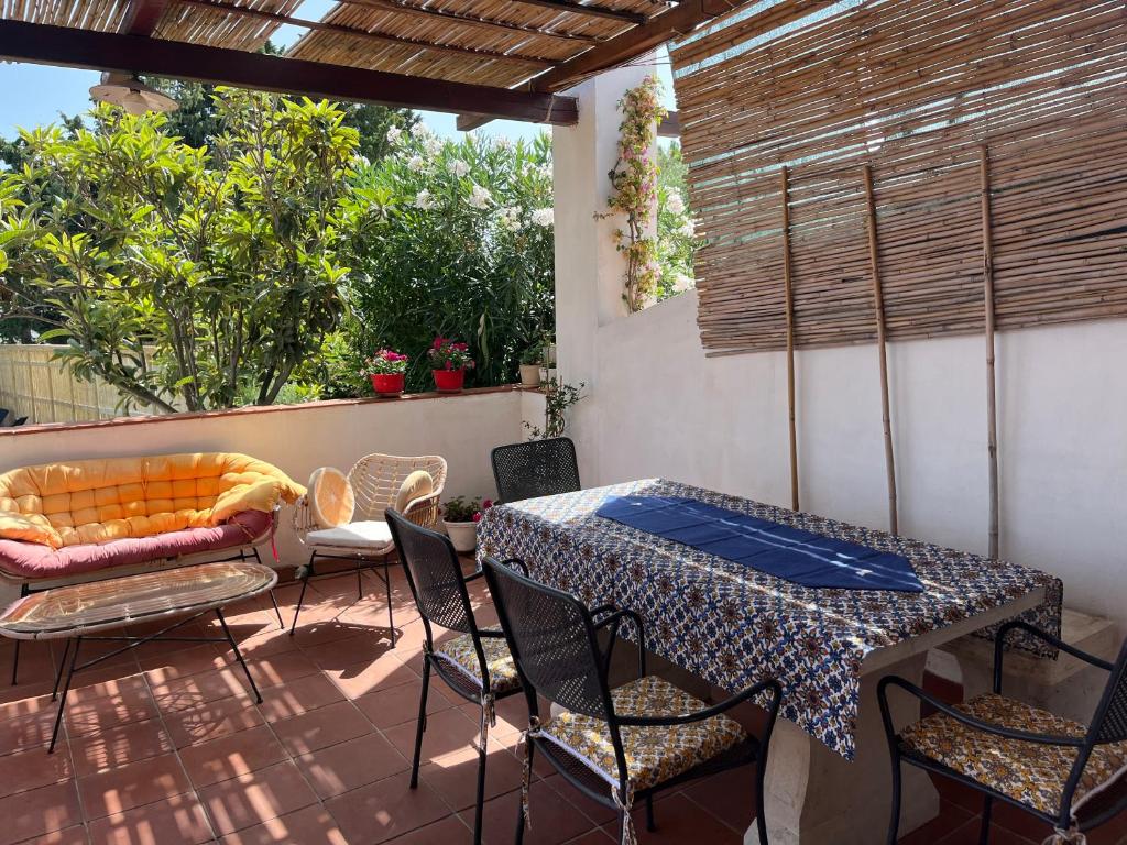 un patio avec une table, des chaises et un canapé dans l'établissement Nettuno 2023, à Marina di Ragusa