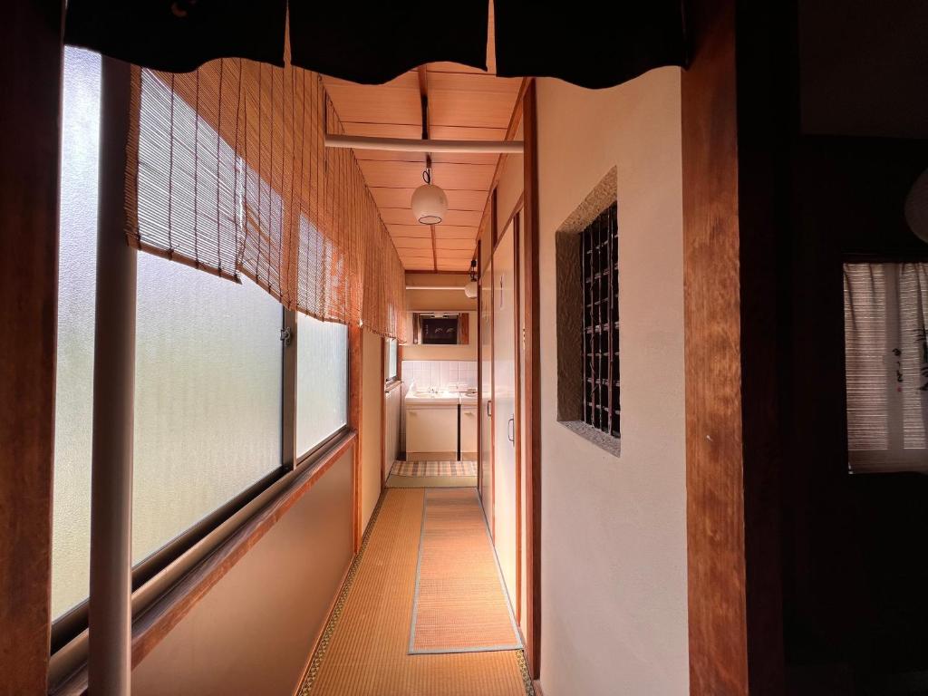 un couloir d'une maison avec des fenêtres et un couloir dans l'établissement Ryokan Sanki, à Kyoto