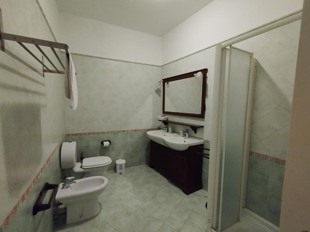 une salle de bain avec un lavabo, des toilettes et un miroir dans l'établissement Villa Terrauzza, à Syracuse