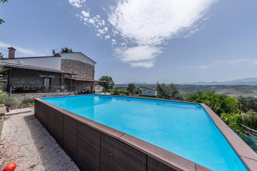 une grande piscine bleue installée à côté d'une maison dans l'établissement Villa Paradiso - Irpinia, à Gesualdo