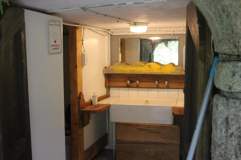 - une petite cuisine avec un évier et un miroir dans l'établissement air naturel de camping moulin de malesse Tipi, à Saint-Privat