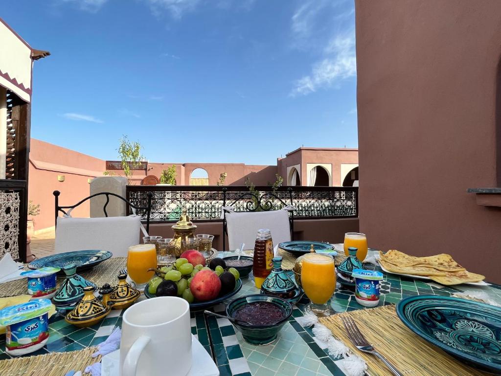 - une table avec des fruits et des jus de fruits sur un balcon dans l'établissement Riad Dar Zaouia, à Marrakech