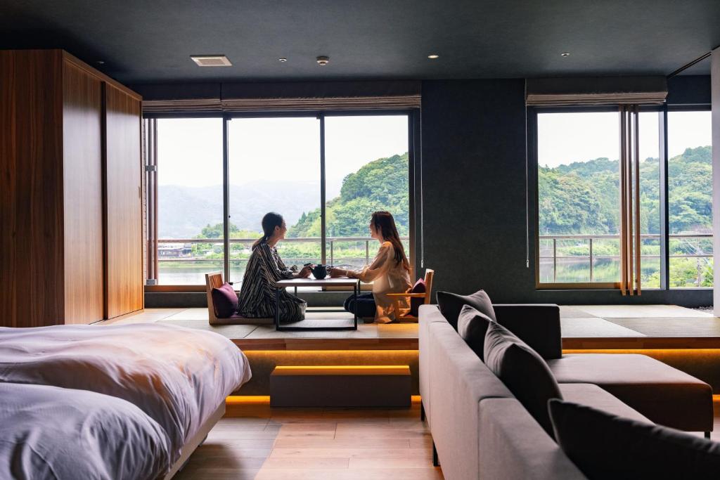 2 personnes assises à une table dans une pièce avec fenêtres dans l'établissement Urari Takeo Garden Terrace Spa Resorts, à Takeo