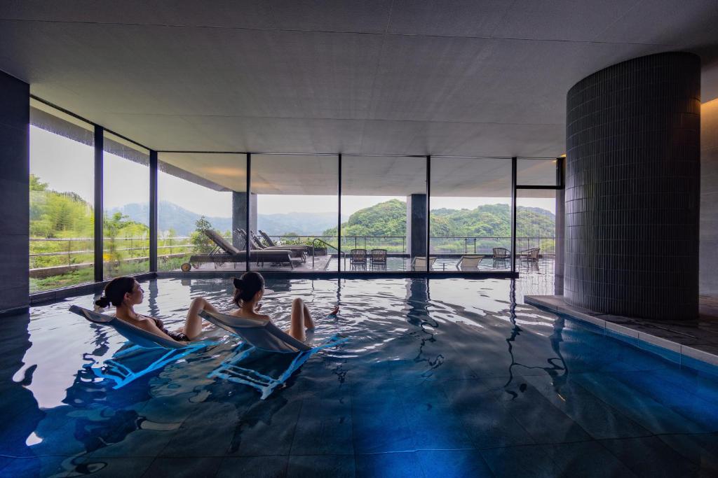 2 personnes assises dans une piscine dans l'établissement Urari Takeo Garden Terrace Spa Resorts, à Takeo