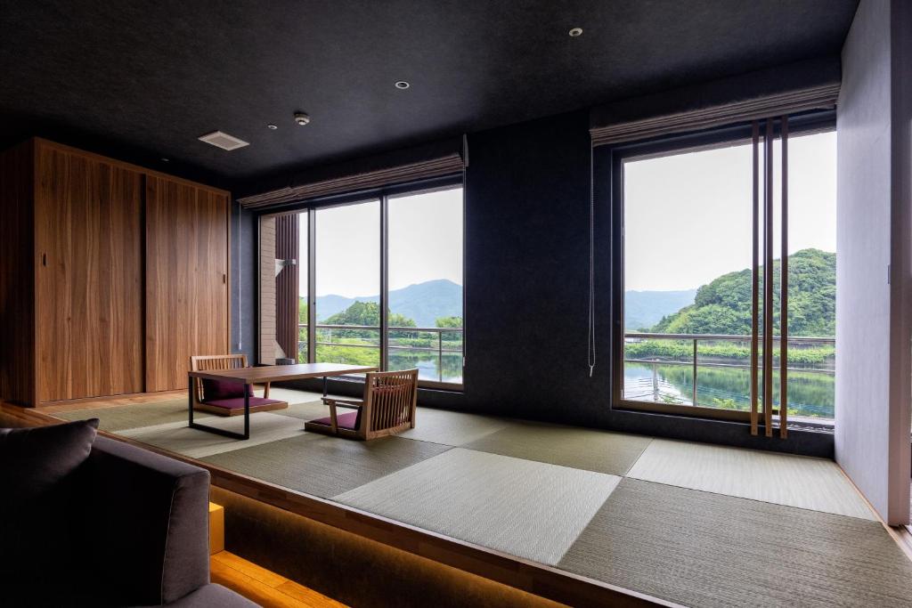 d'une salle à manger avec une table et de grandes fenêtres. dans l'établissement Urari Takeo Garden Terrace Spa Resorts, à Takeo