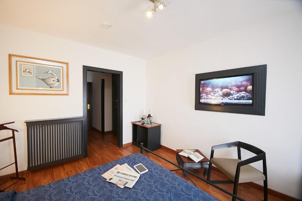 un salon avec une télévision au mur dans l'établissement Hotel Enterprise, à Montalto di Castro