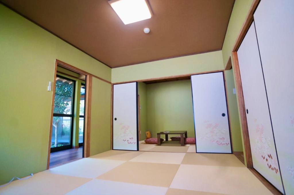 une pièce vide avec des murs verts et un plafond dans l'établissement Takaosou, à Yufu