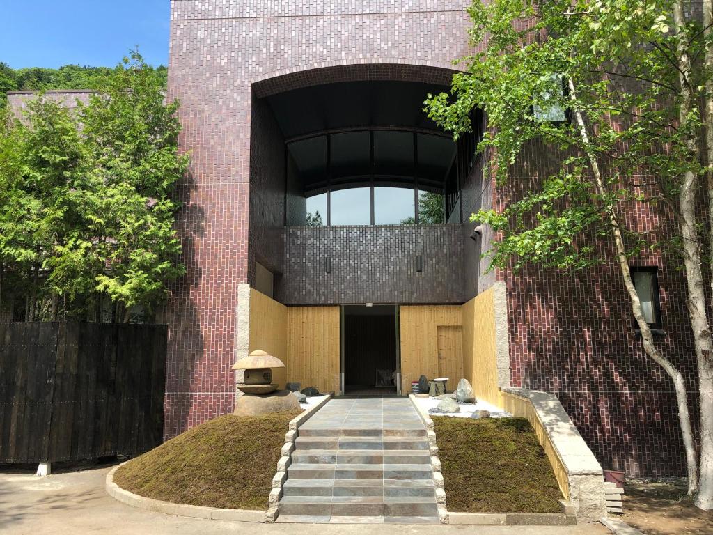 un bâtiment en briques avec un escalier menant à une porte dans l'établissement Suigan, à Jozankei