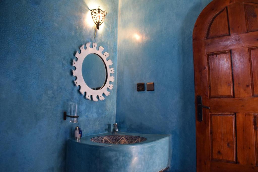 une salle de bain avec un lavabo et un miroir au mur dans l'établissement Riad Saltana, à Essaouira
