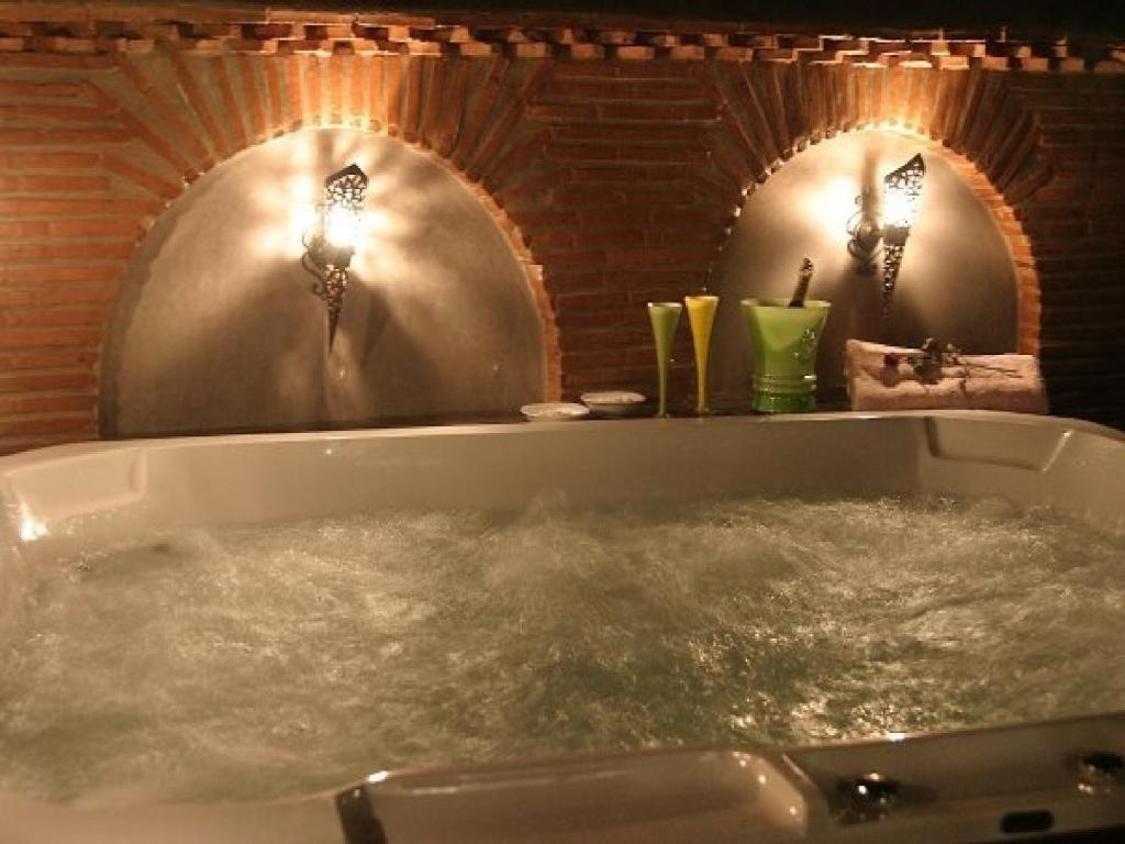 une baignoire remplie d'eau devant deux miroirs dans l'établissement Riad Carllian, à Marrakech