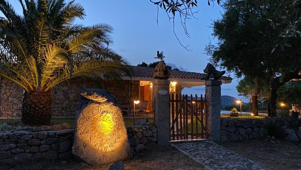 une maison avec une clôture et un vase devant un portail dans l'établissement Villa De La Seliga, à Sant Antonio Di Gallura