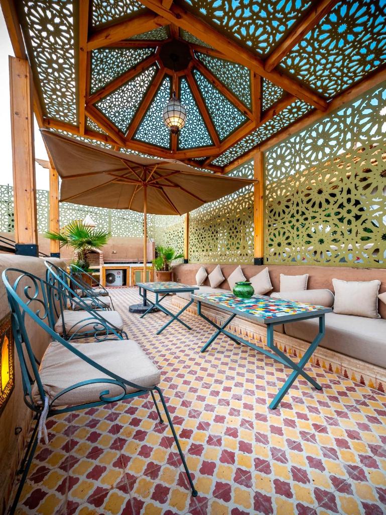 - une terrasse avec 2 chaises, un canapé et un parasol dans l'établissement Riad La Croix Berbere, à Marrakech 37 autres photos
