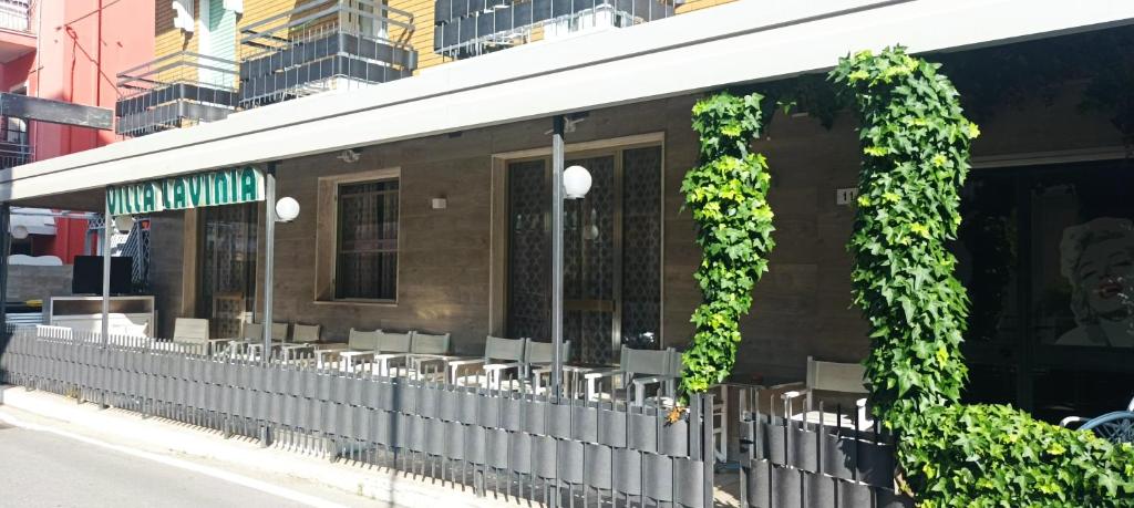 un bâtiment avec du lierre sur son côté dans l'établissement Villa Lavinia, à Rimini