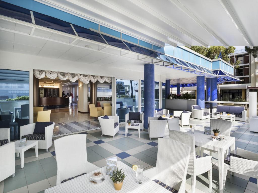 une représentation d'un restaurant avec des tables et des chaises blanches dans l'établissement Hotel San Michele, à Bibione