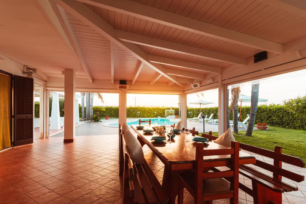 d'une terrasse avec une grande table et des chaises en bois. dans l'établissement Villa Volare, à Polignano a Mare