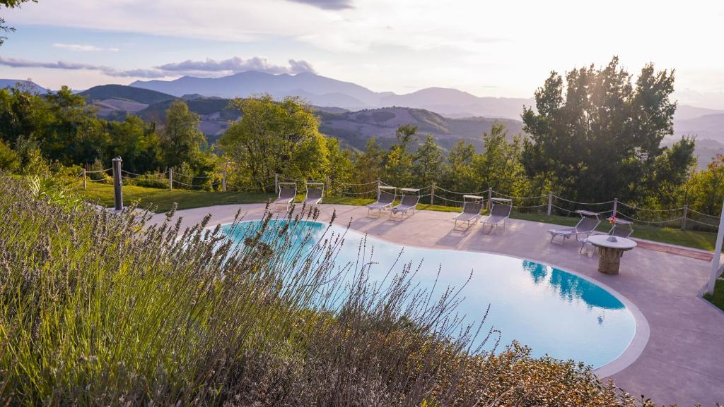- une piscine avec des chaises et une vue sur les montagnes dans l'établissement Casa Bartoccio - Casa vacanze, à Fermignano
