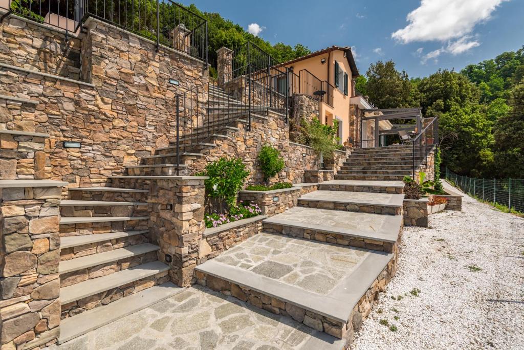 un mur en pierre avec des escaliers à côté d'un bâtiment dans l'établissement Villa Passione, à Lerici