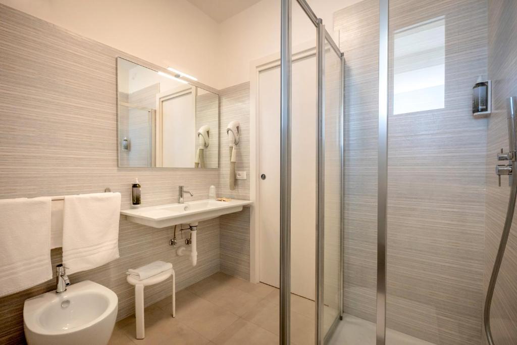 une salle de bain avec toilettes, lavabo et douche dans l'établissement Hotel Parigi, à Caorle