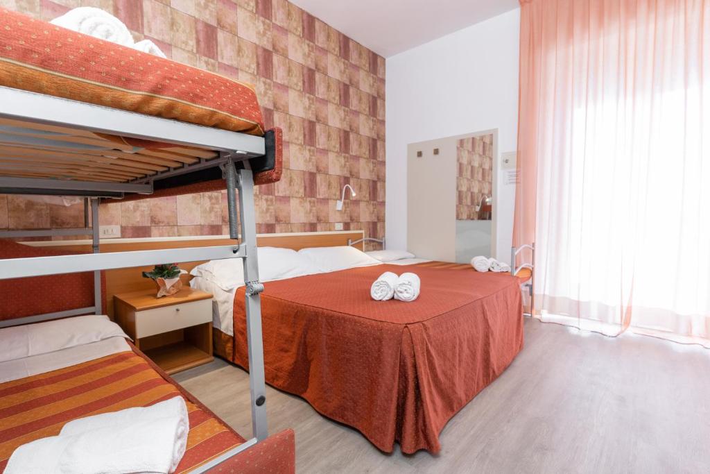 une chambre avec deux lits superposés et une table dans l'établissement Hotel Dusseldorf, à Rimini